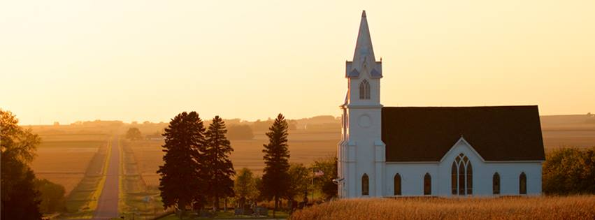 An image of a church at sunset on the rural prairie.